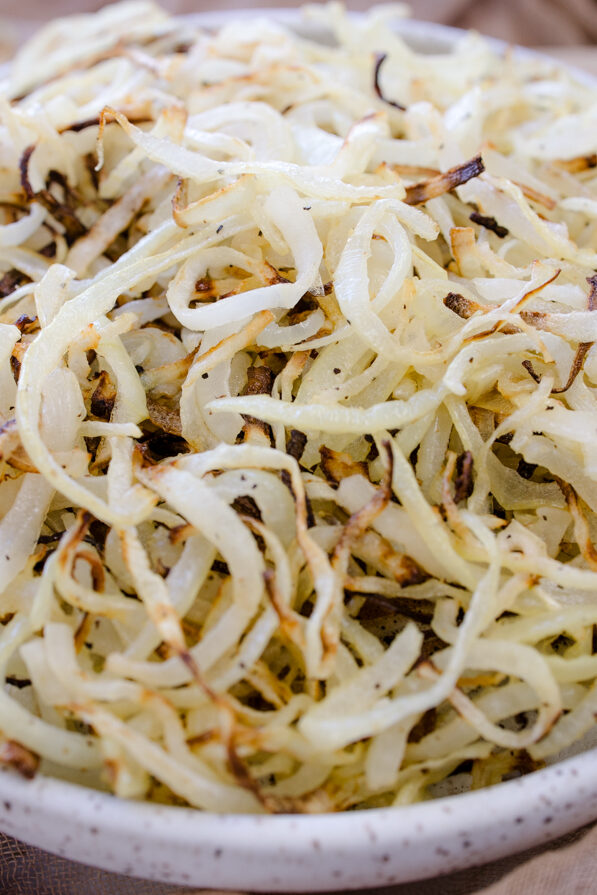 Angled view of a white plate full of Air Fryer Onions.