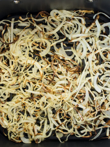 Overhead view of Air Fryer Onions in an air fryer basket.