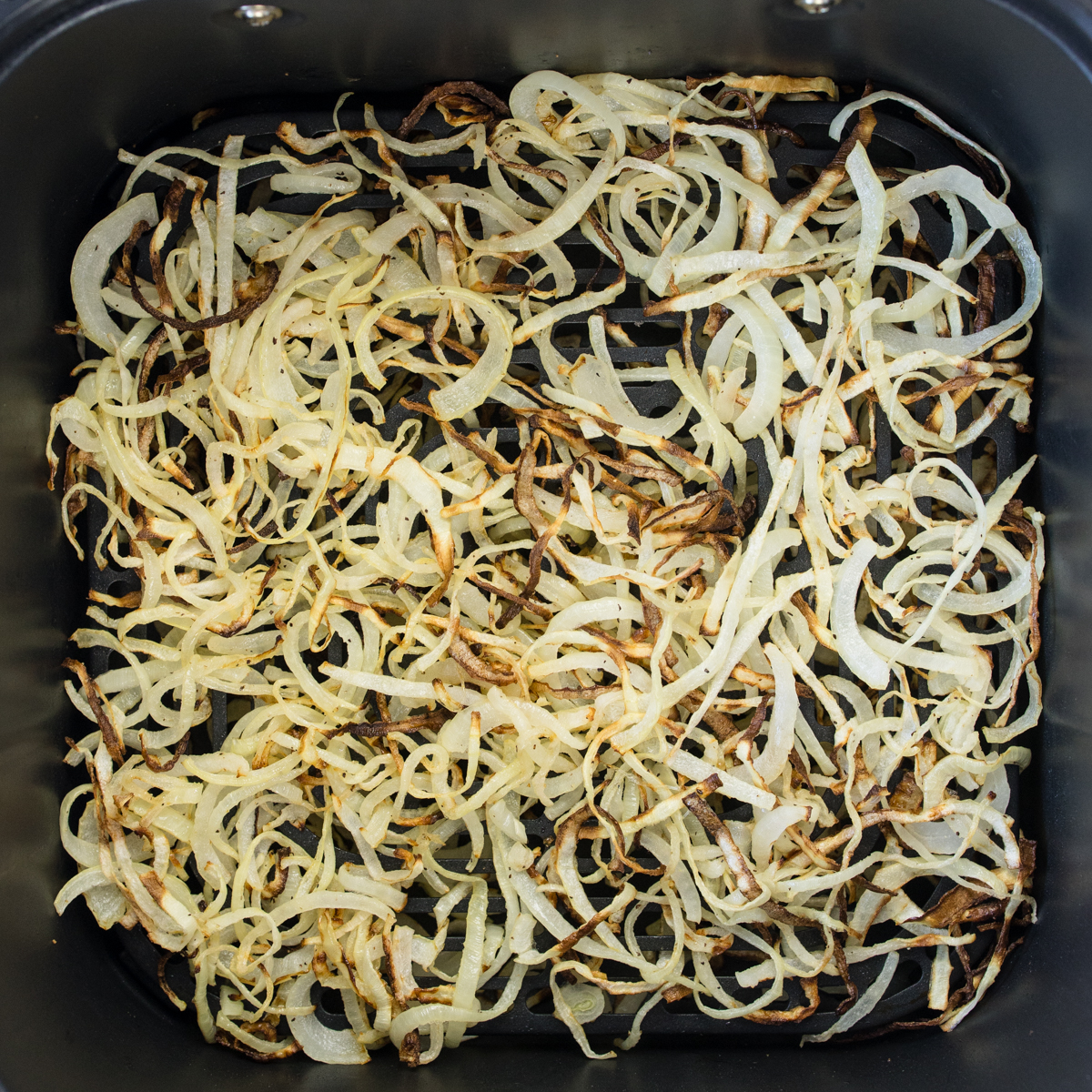 Overhead view of Air Fryer Onions in an air fryer basket.