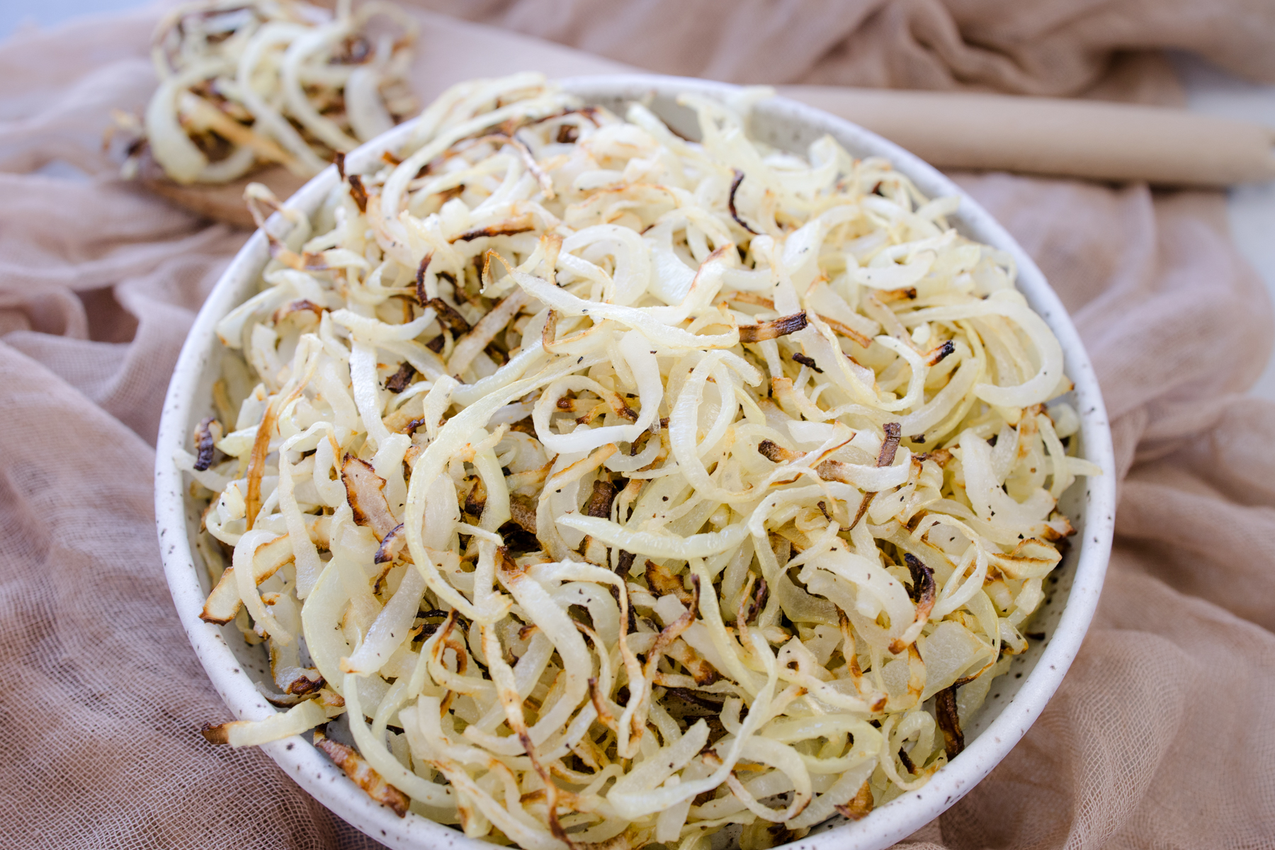 Angled view of a white plate full of Air Fryer Onions.