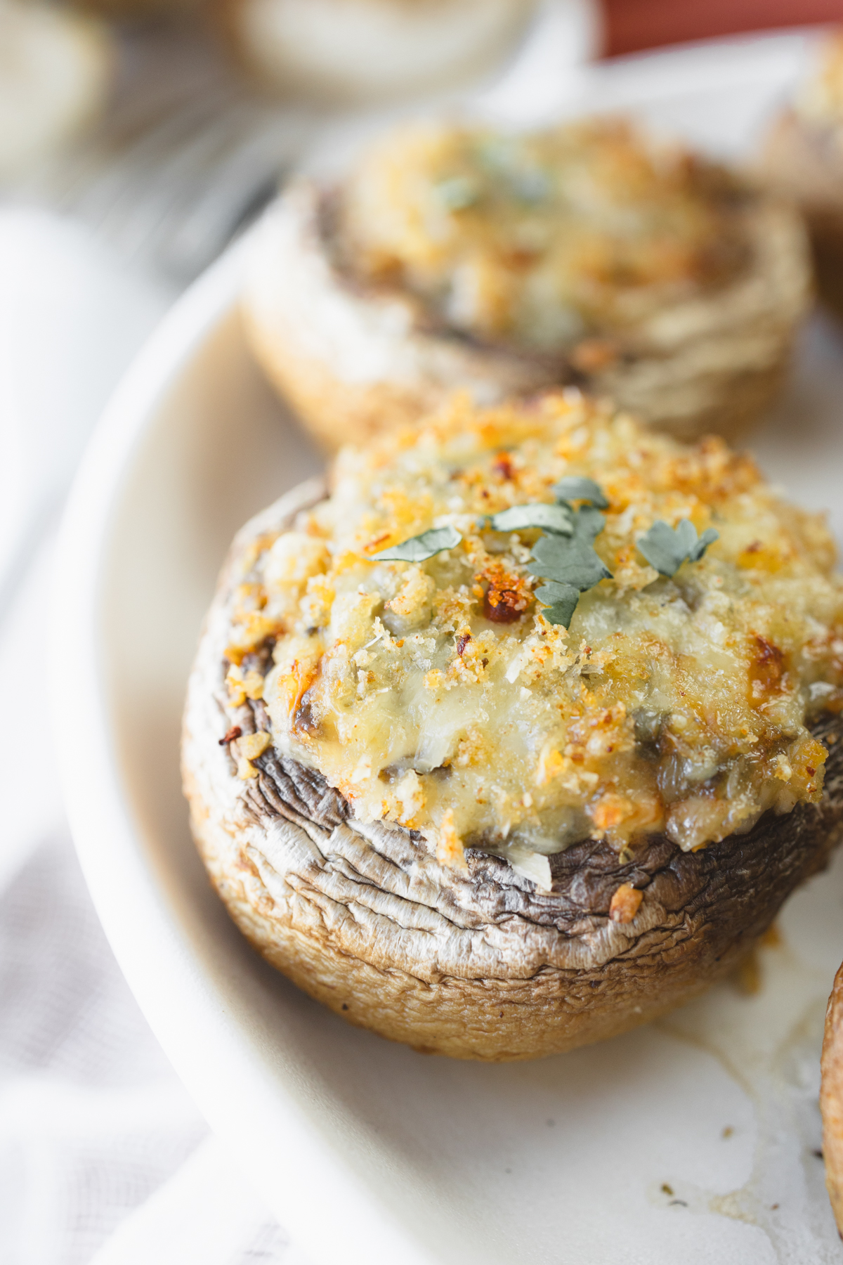 Close up image of Air Fryer Stuffed Mushrooms on a white plate.