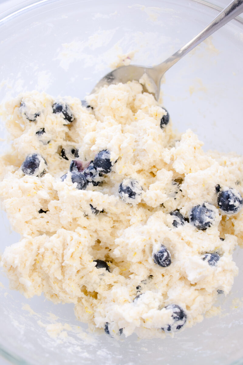 Angled view of blueberry biscuit dough being mixed together.