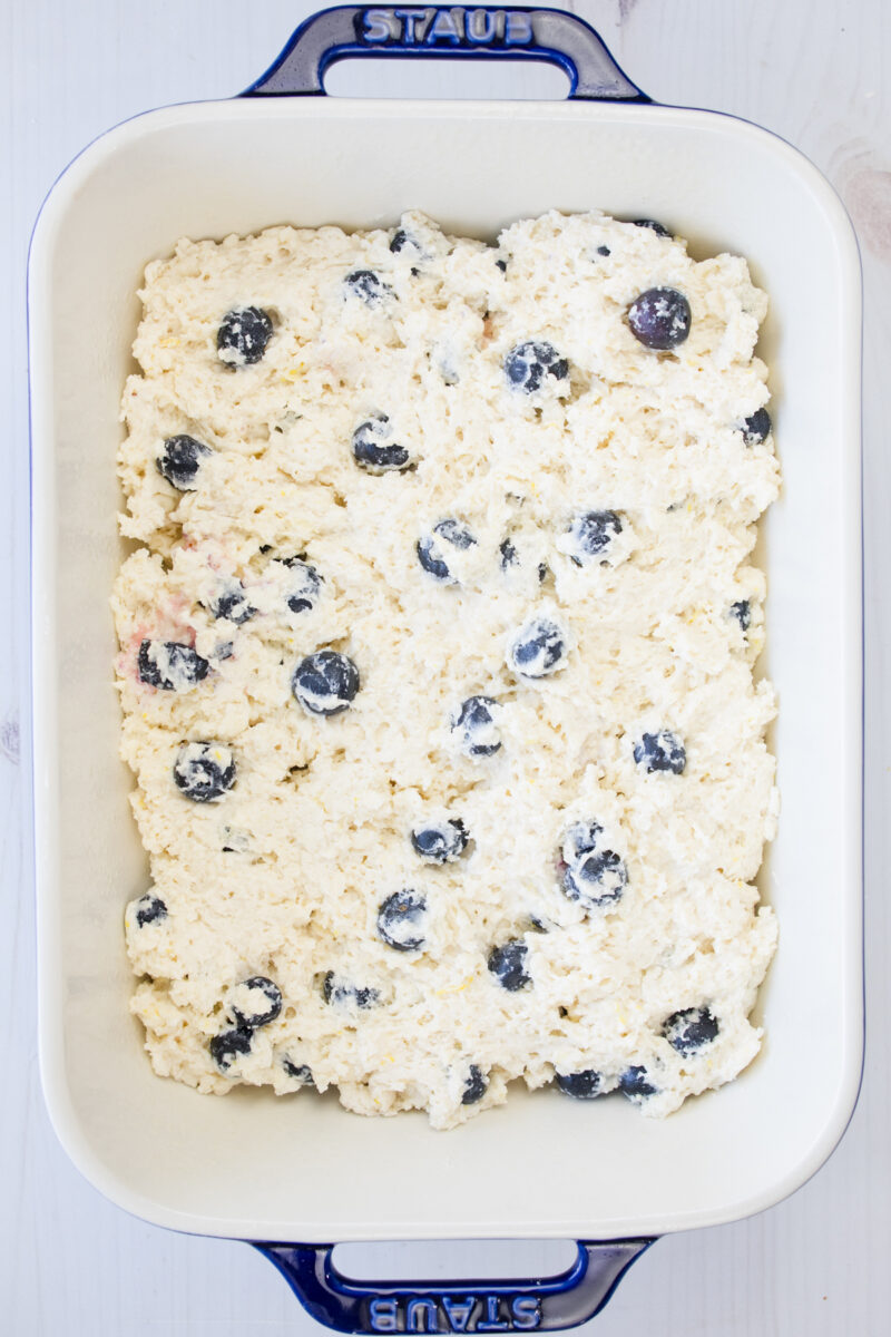Overhead view of blueberry biscuit dough in a rectangular baking dish.
