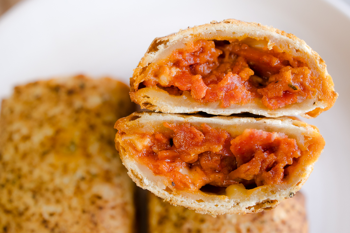 Close up view of a Hot Pocket sliced in half to reveal the middle.
