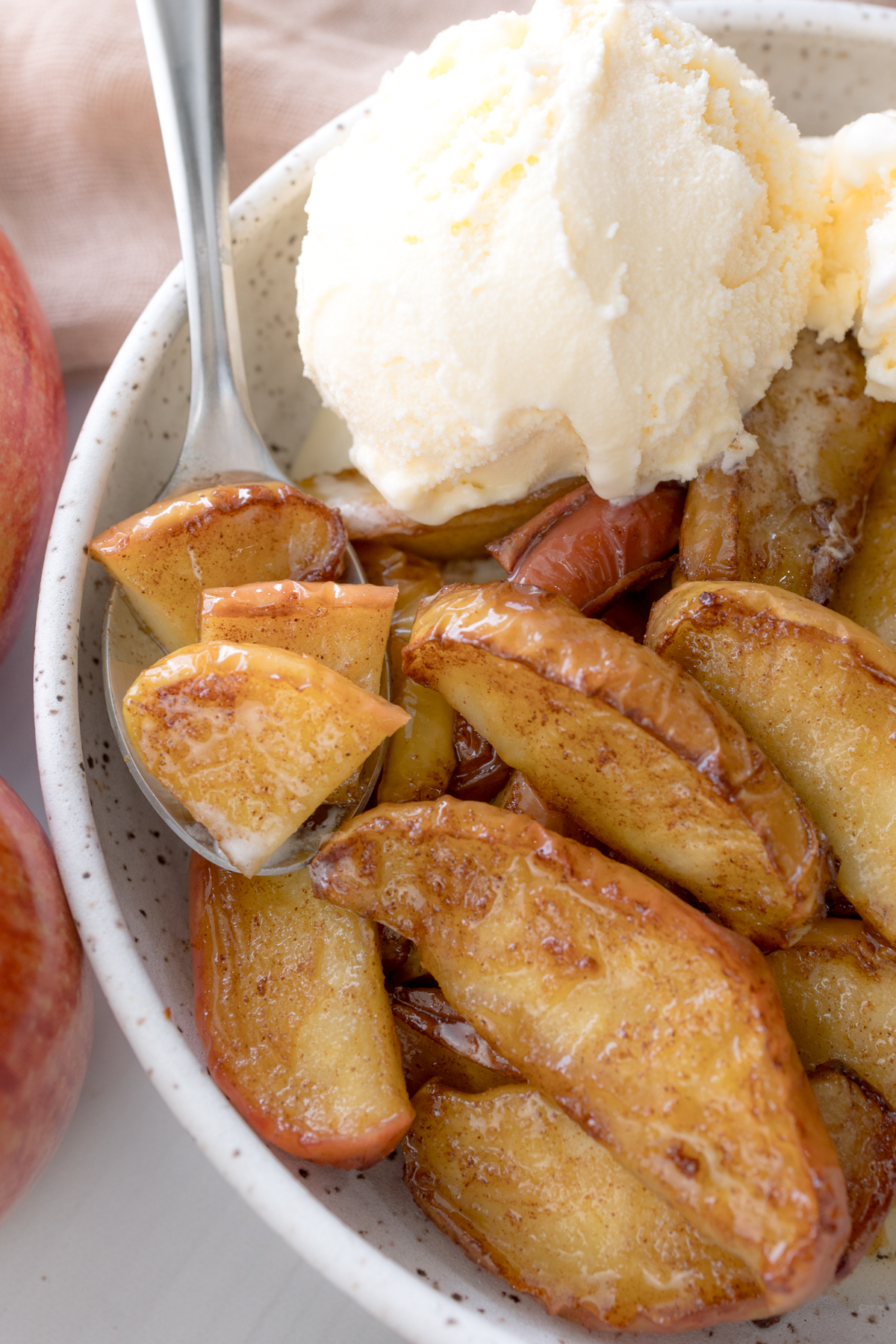 Overhead view of Air Fryer Apples in a bowl with vanilla ice cream.