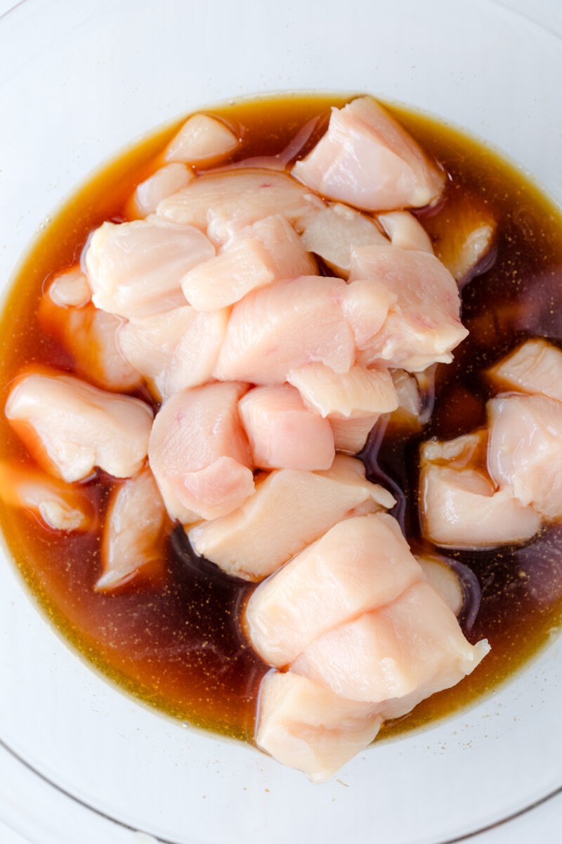 Overhead view of uncooked chicken Teriyaki marinating in a glass bowl