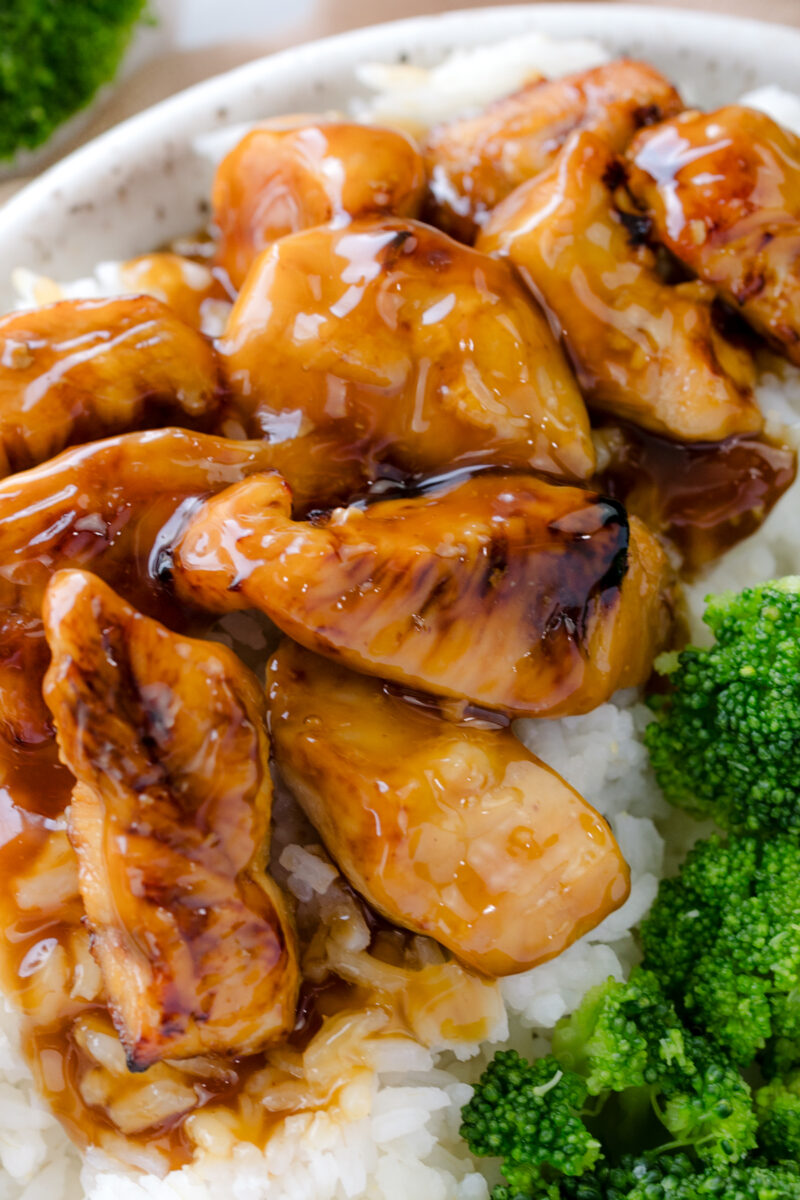 Close up image of Air Fryer Teriyaki Chicken on a white plate with rice and broccoli.