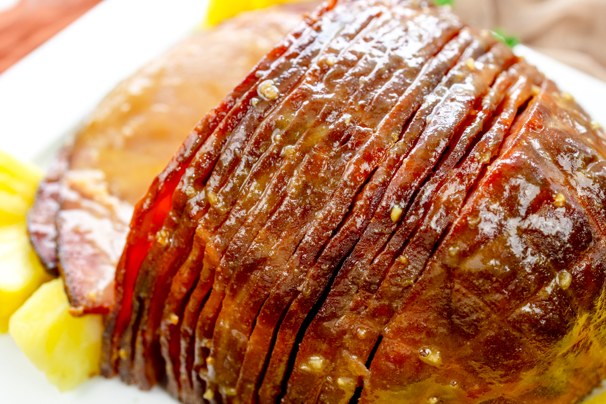 Close up view of Air Fryer Ham on a white plate with pineapple chunks.