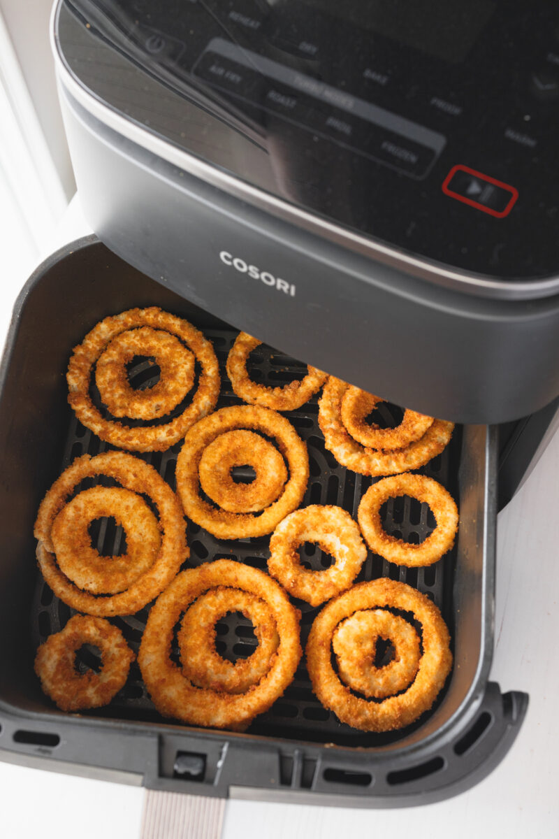 Angled view of Onion Rings in an air fryer basket.
