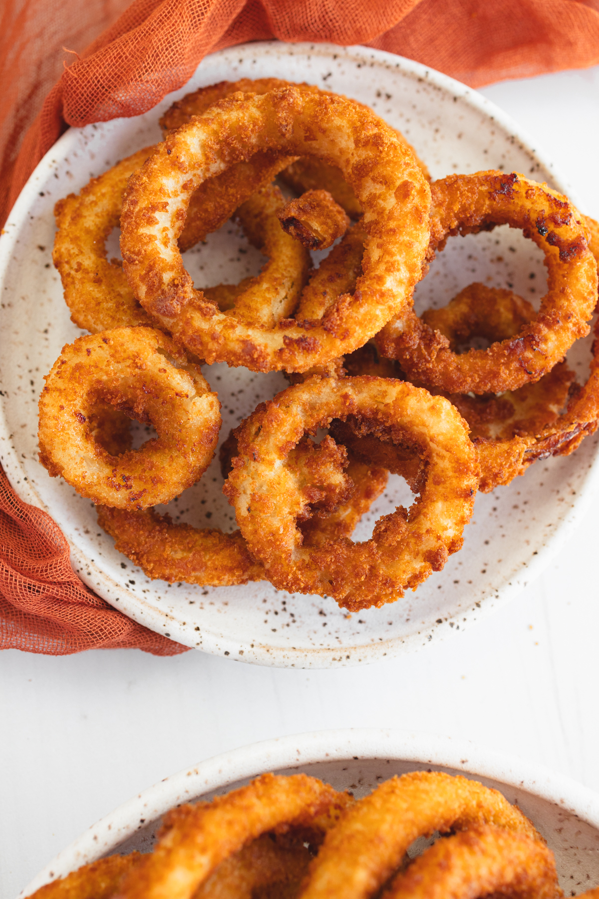 Angled view of a plate of Onion Rings.