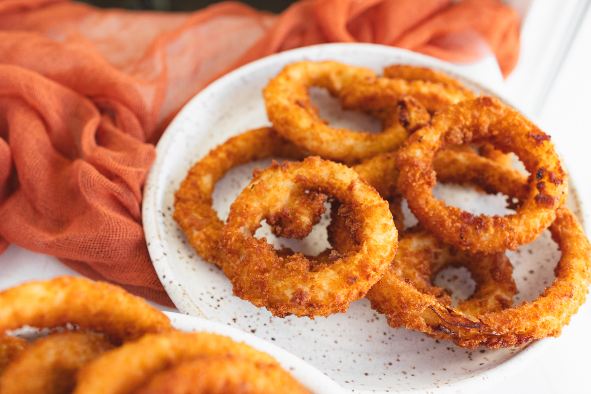 Angled view of a plate of Onion Rings.