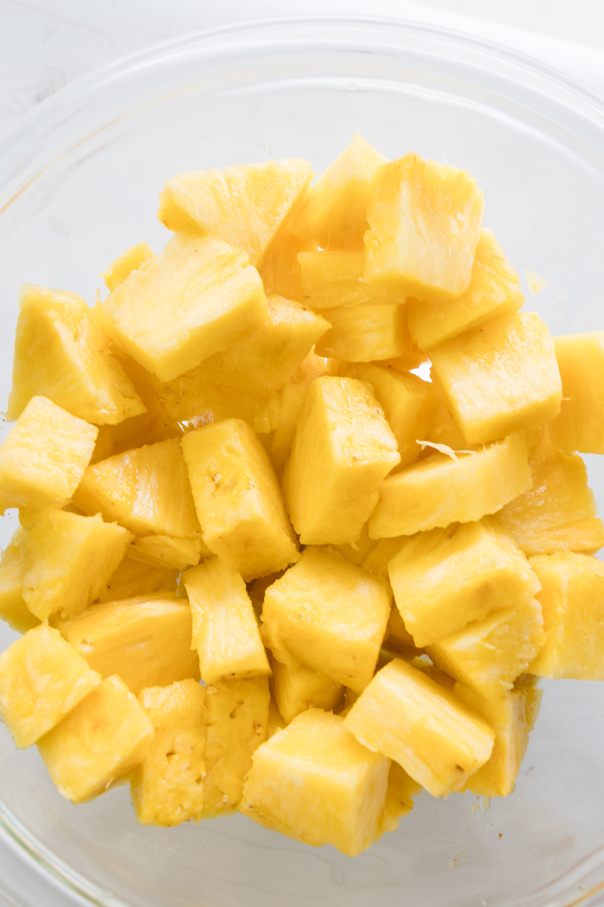 Close up overhead view of pineapple chunks in a glass dish.