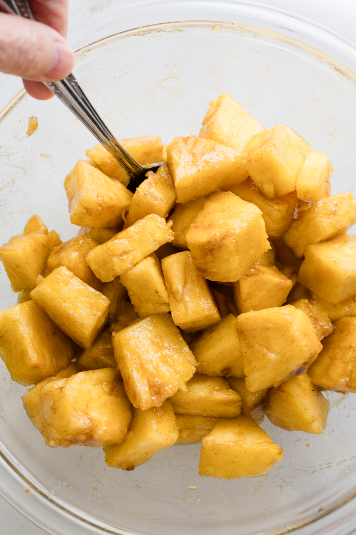 Overhead view of pineapple chunks in a glass dish.