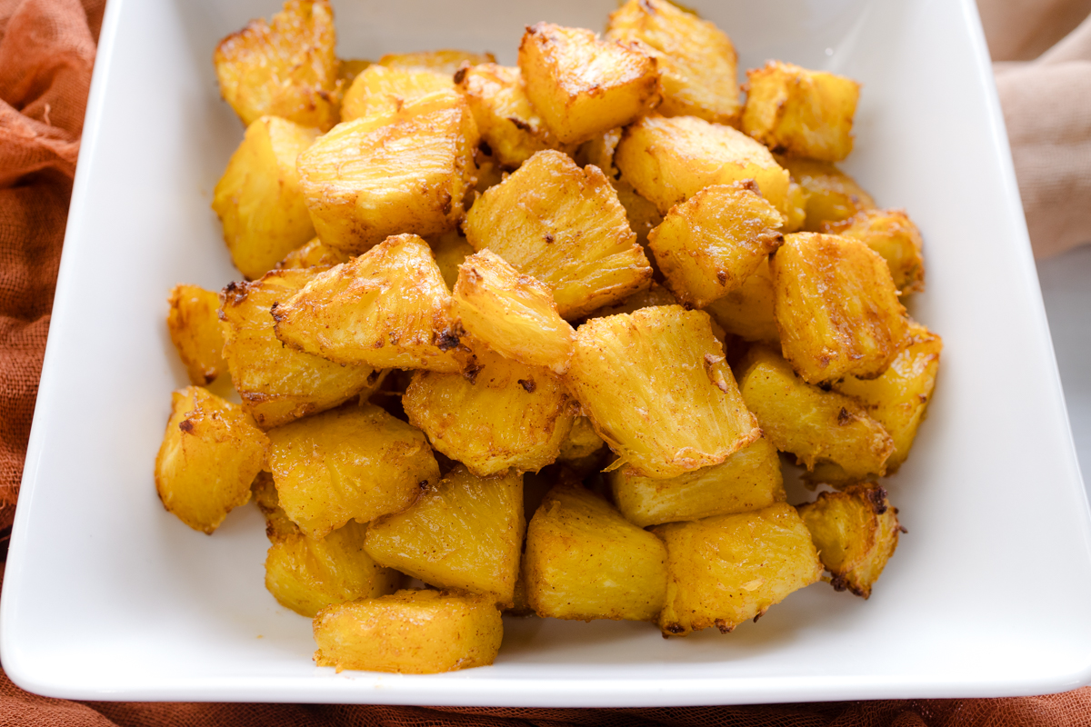 Angled view of Air Fryer Pineapple in a square, white dish.
