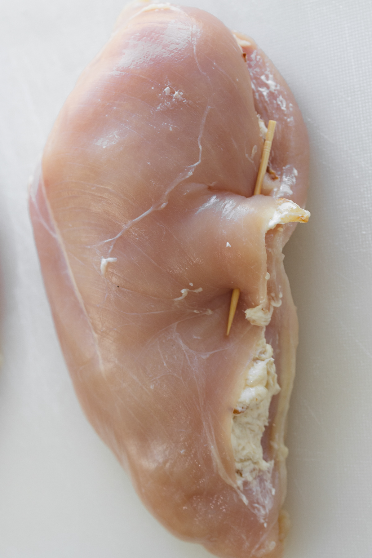 Close up overhead view of a sliced chicken breast that's been stuffed with filling, closed over.