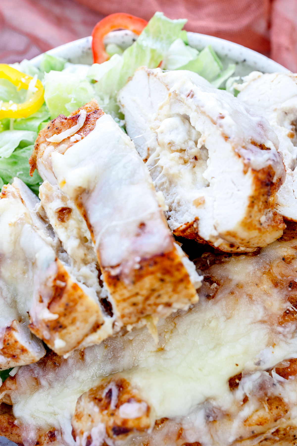 Close up overhead view of Air Fryer Stuffed Chicken on a plate with salad.