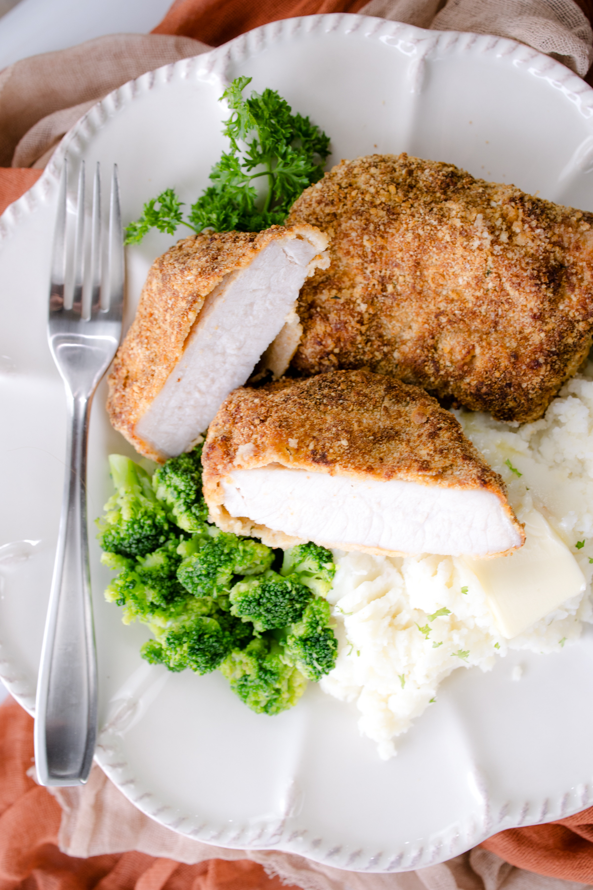 Golden brown pork chops sliced and served with favorite sides like broccoli.