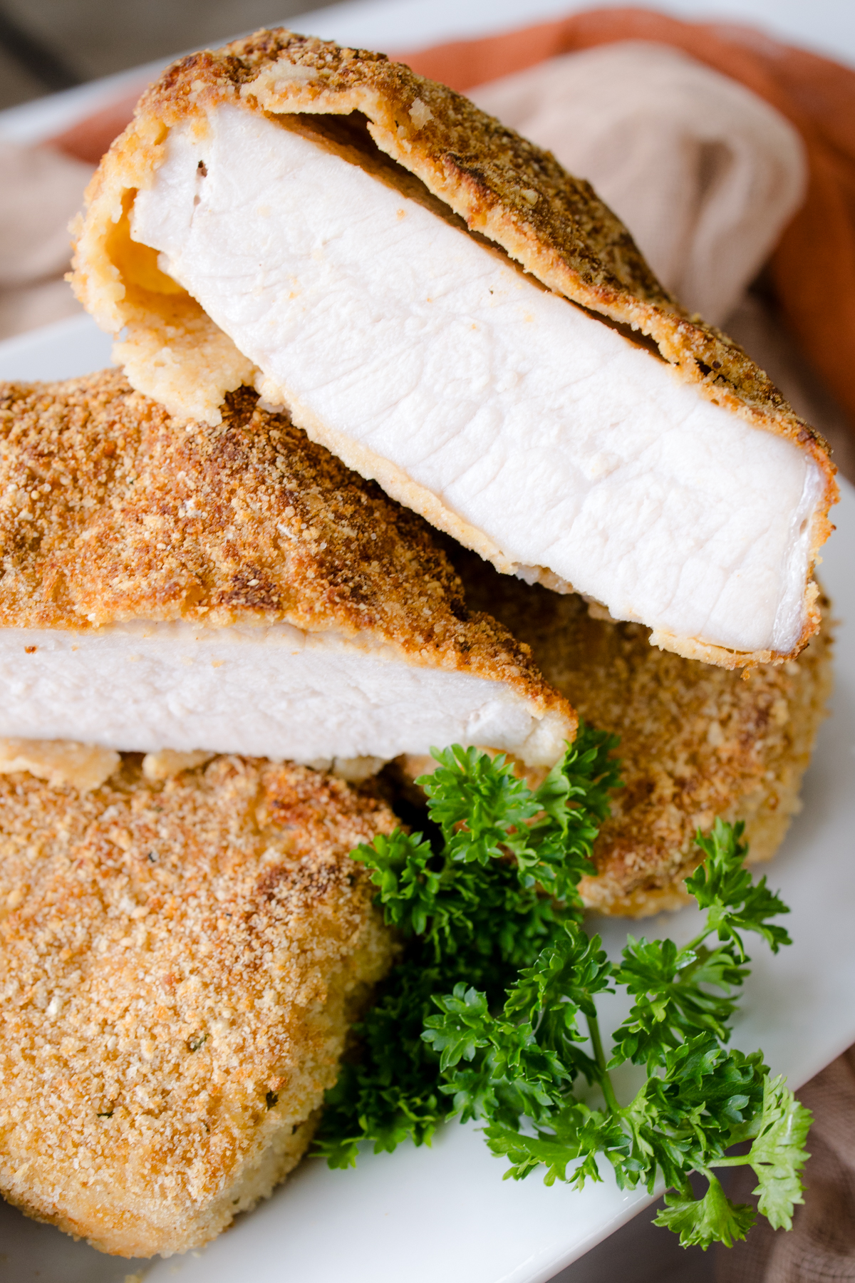 Close up of juicy pork chops sliced to show tender pork and crunchy breading.