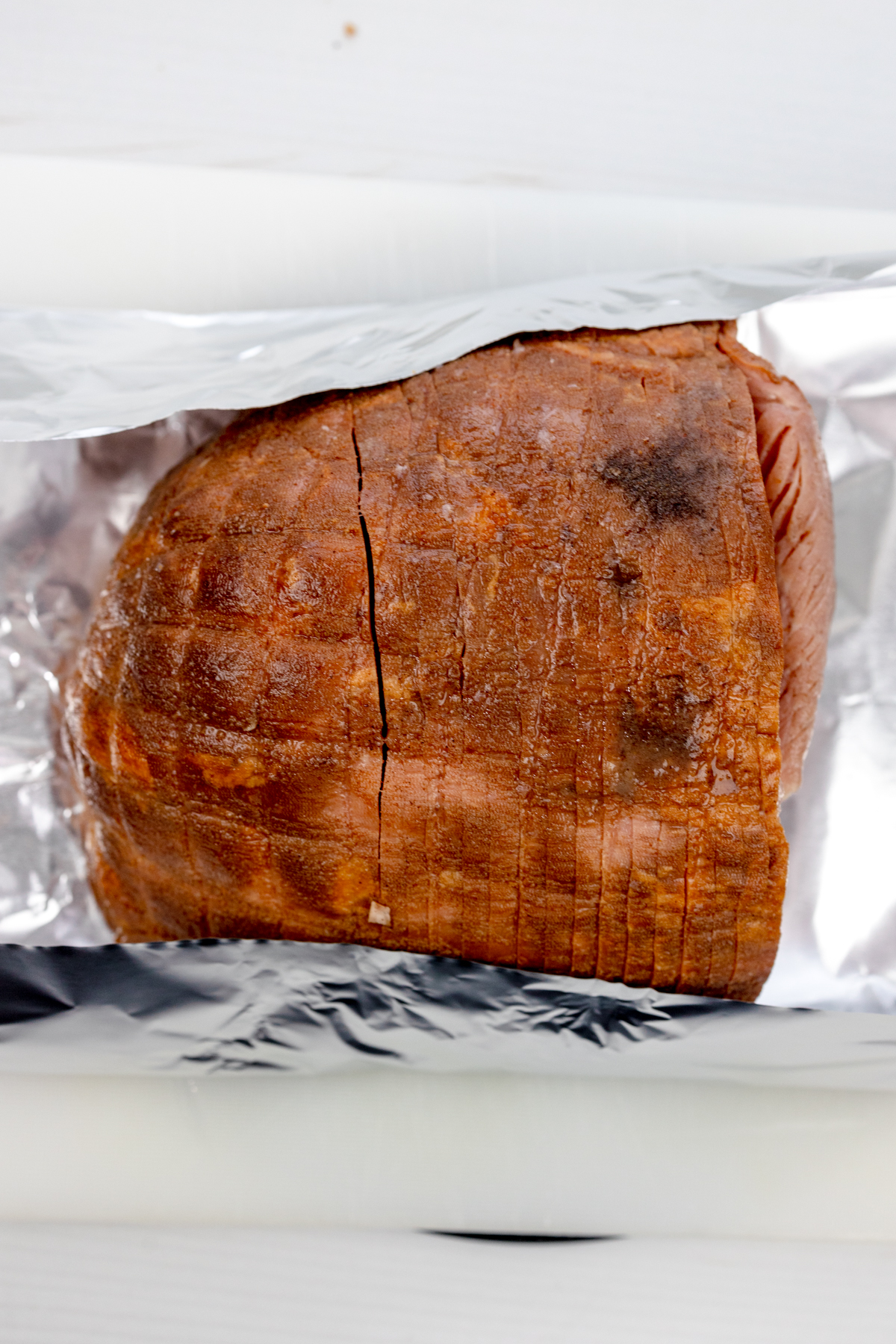 Overhead view of unwrapped, cooked air fryer ham, still in the tinfoil.