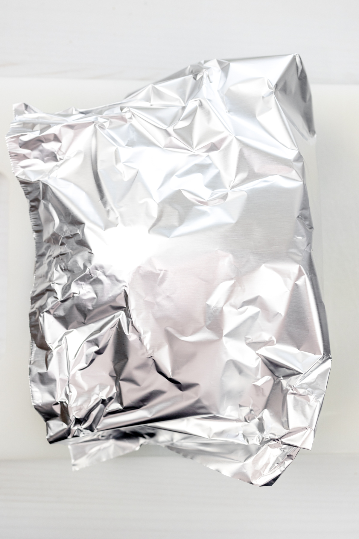 Overhead of a ham wrapped in tinfoil.