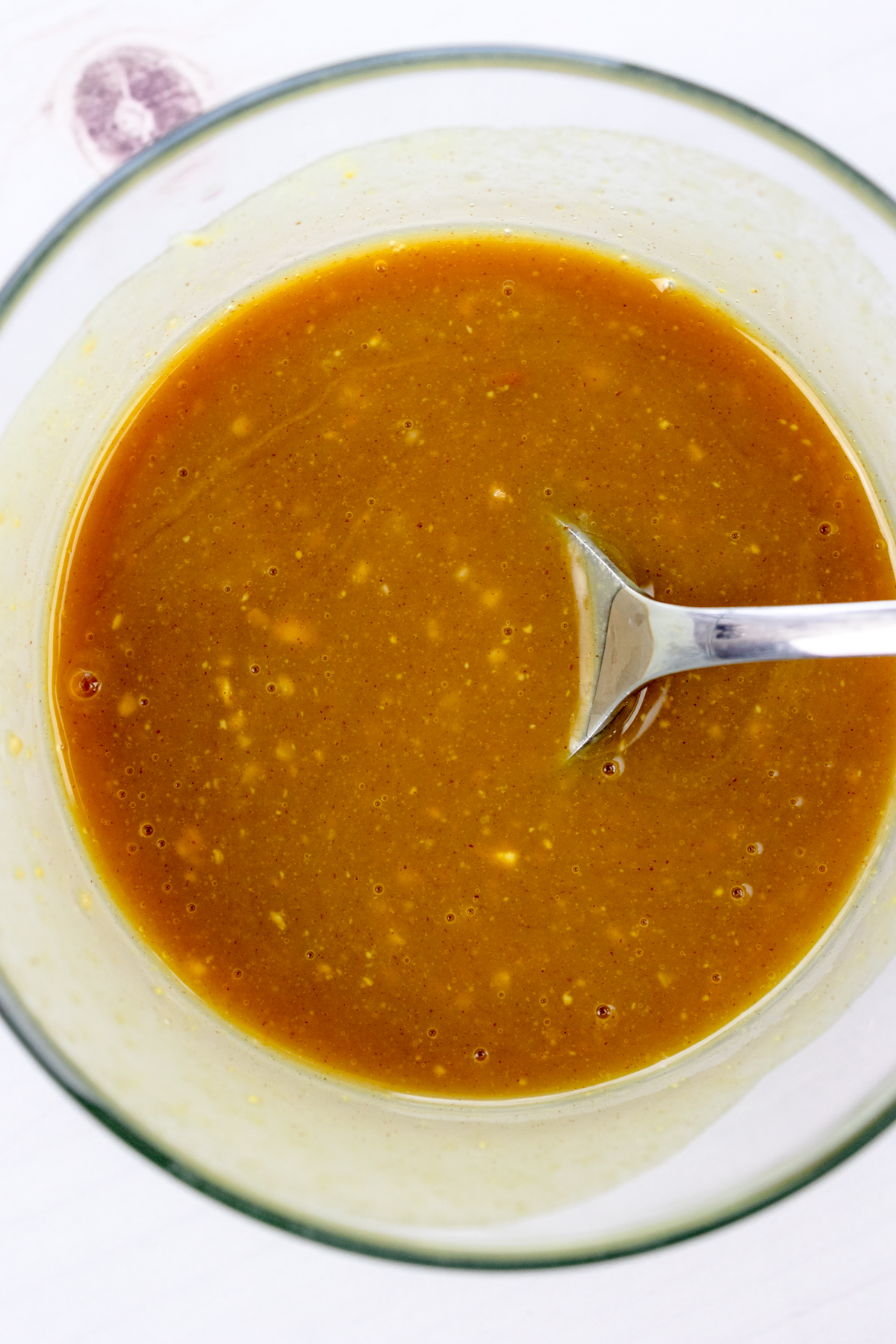 Overhead view of basting sauce for air fryer ham in a glass bowl.
