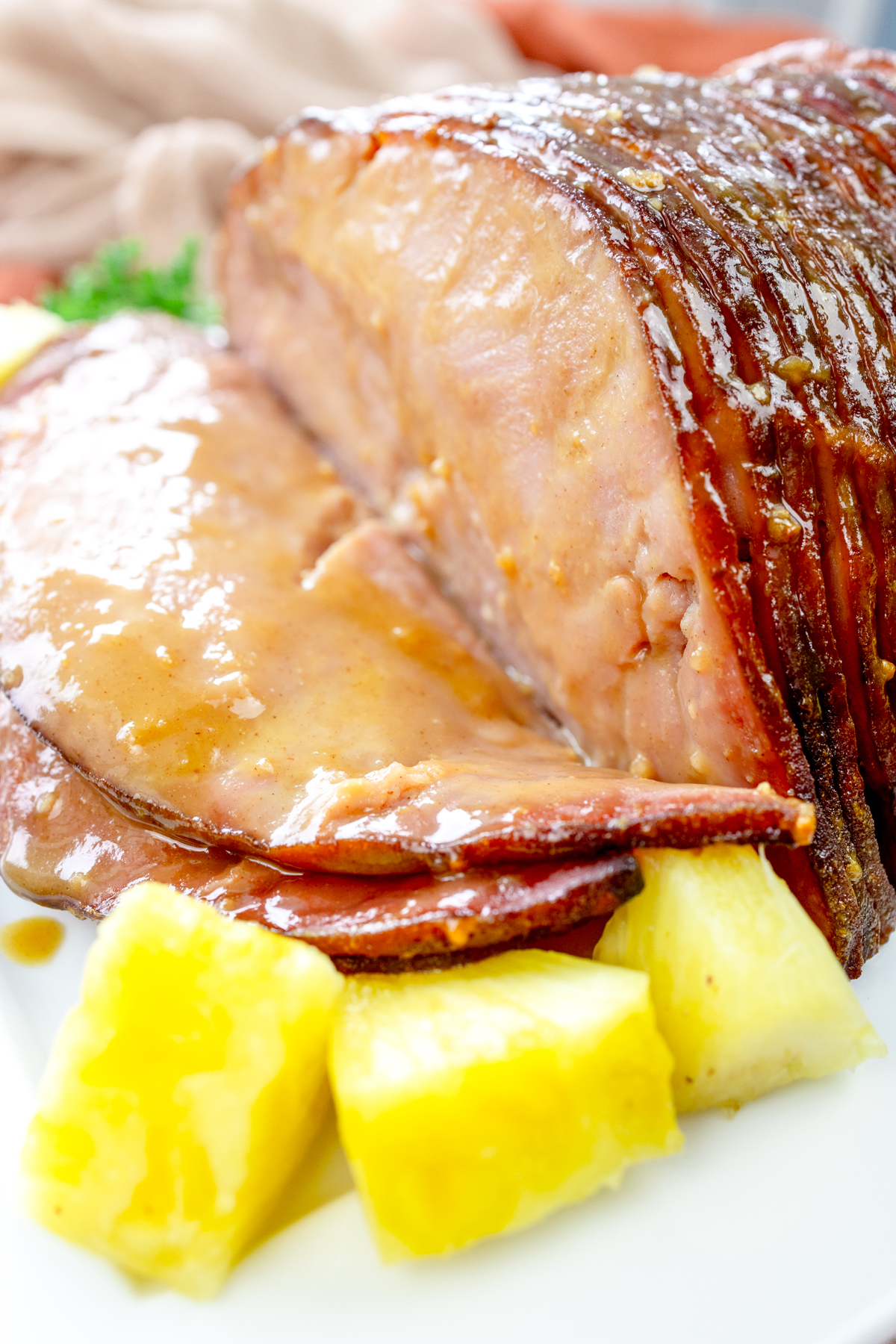 Angled view of Air Fryer Ham on a white plate with pineapple chunks.