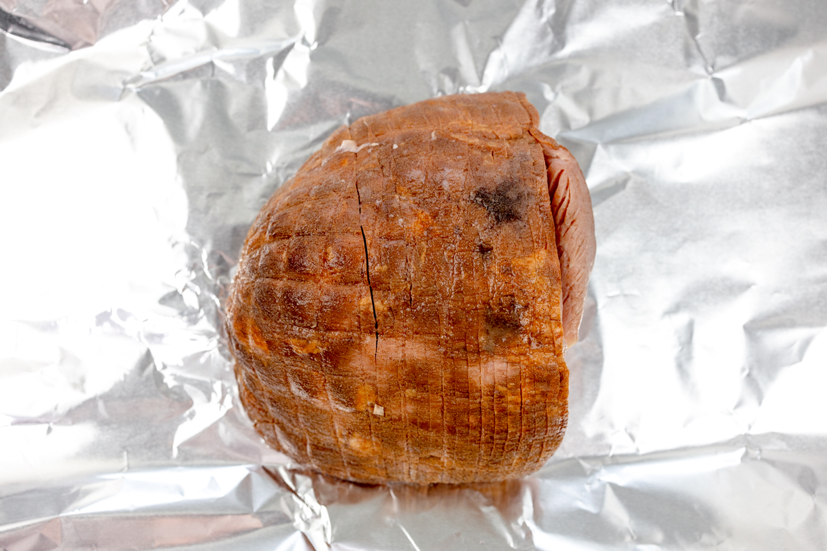 Overhead view of a ham on a sheet of tinfoil.