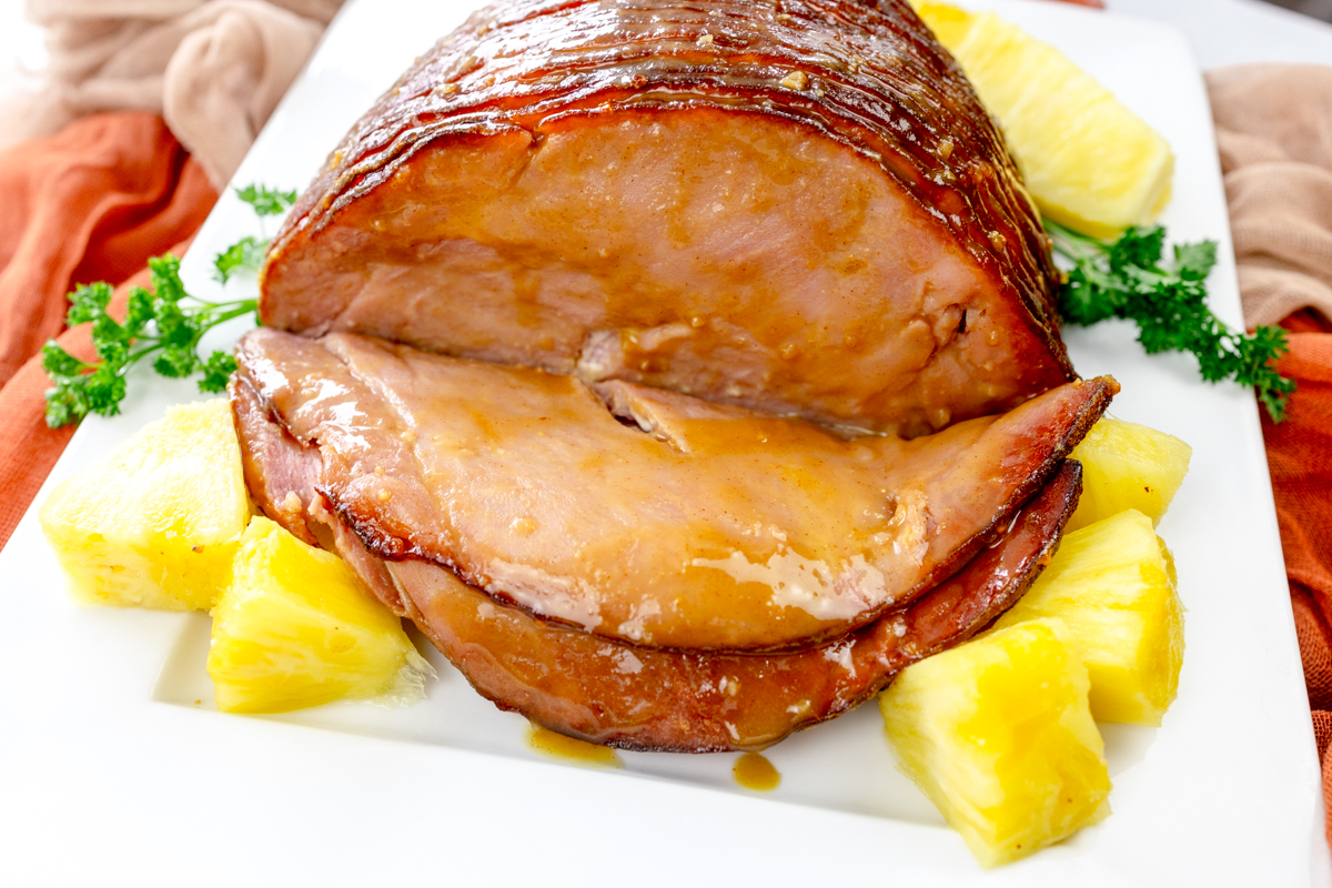 Angled view of Air Fryer Ham on a white plate with pineapple chunks.